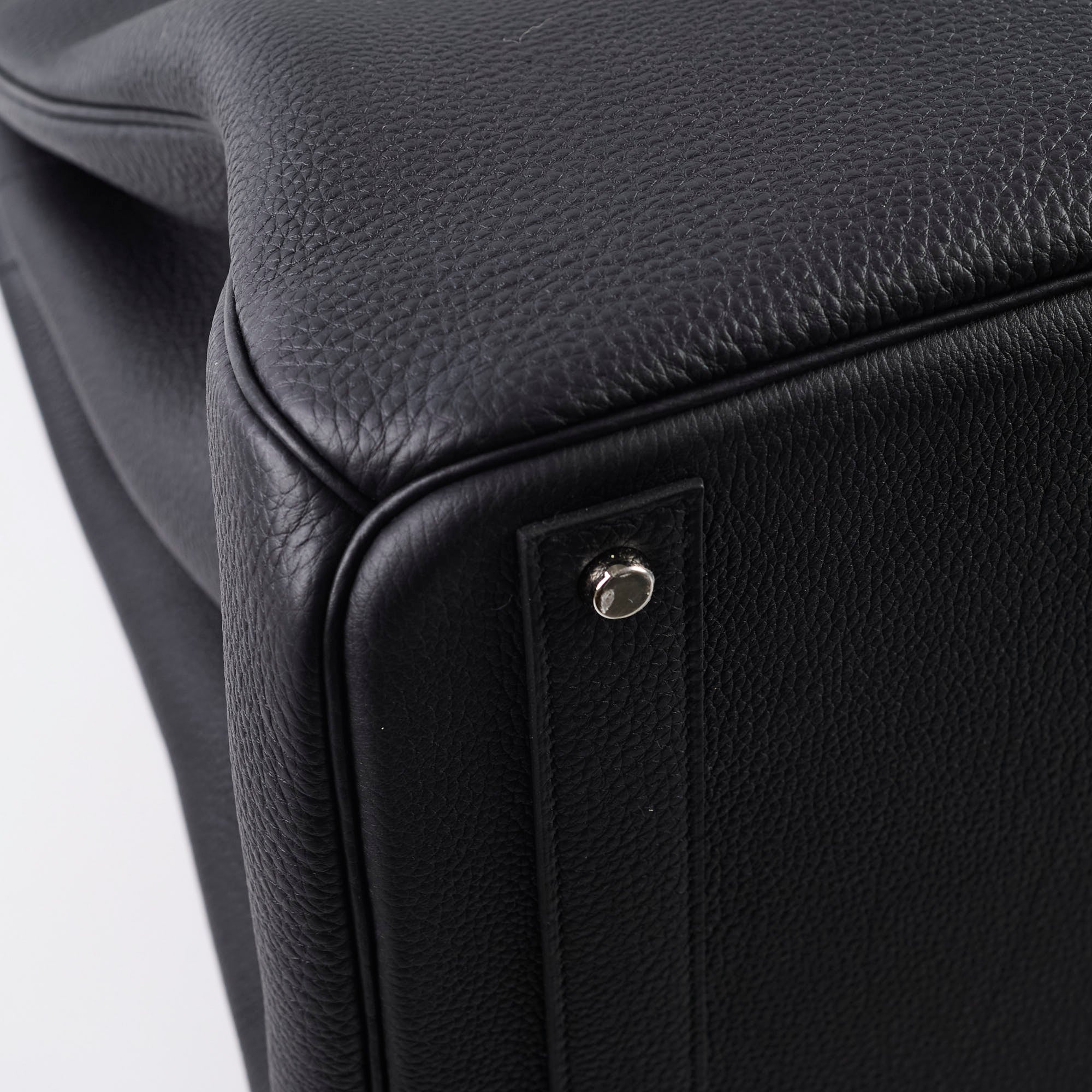 Close-up of a black leather product with a metallic accent 